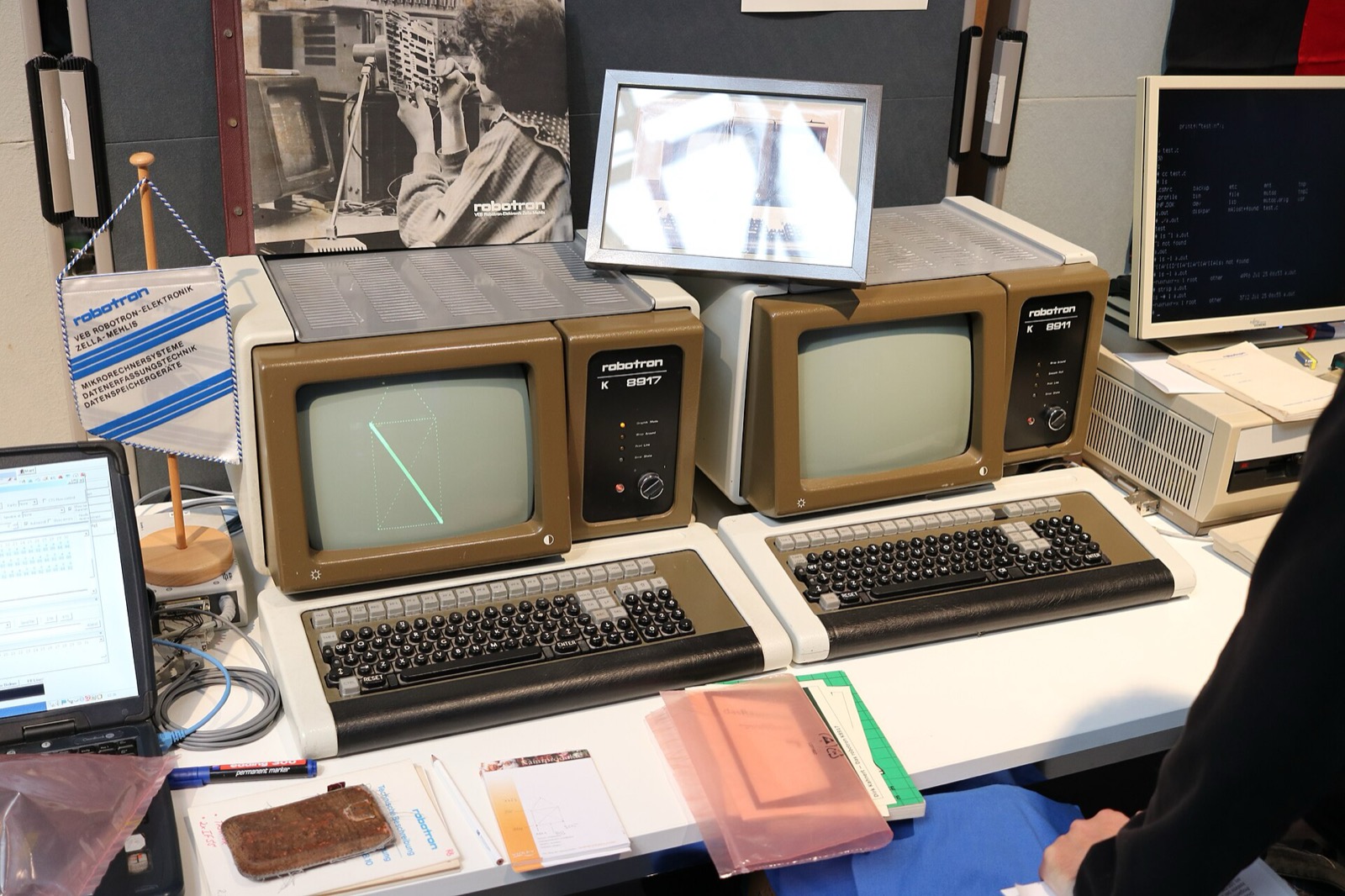 Two early-1980s Robotron computer terminals with amber CRTs and mechanical keyboards