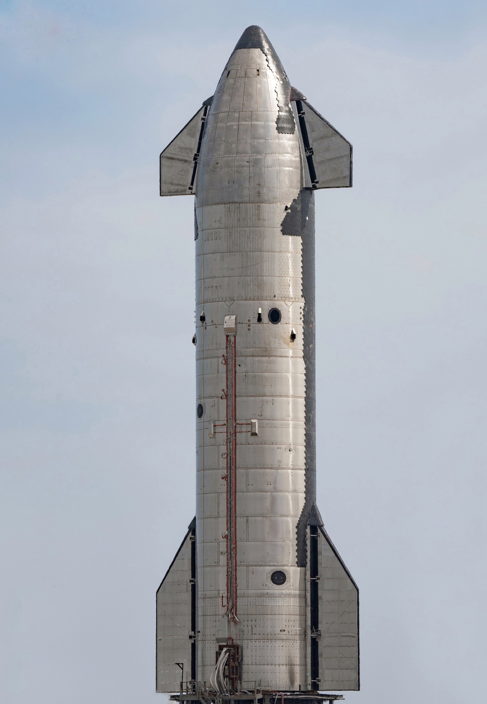 Starship S20 on the ground, showing its forward and aft flaps and the edge of the tiled heat shield