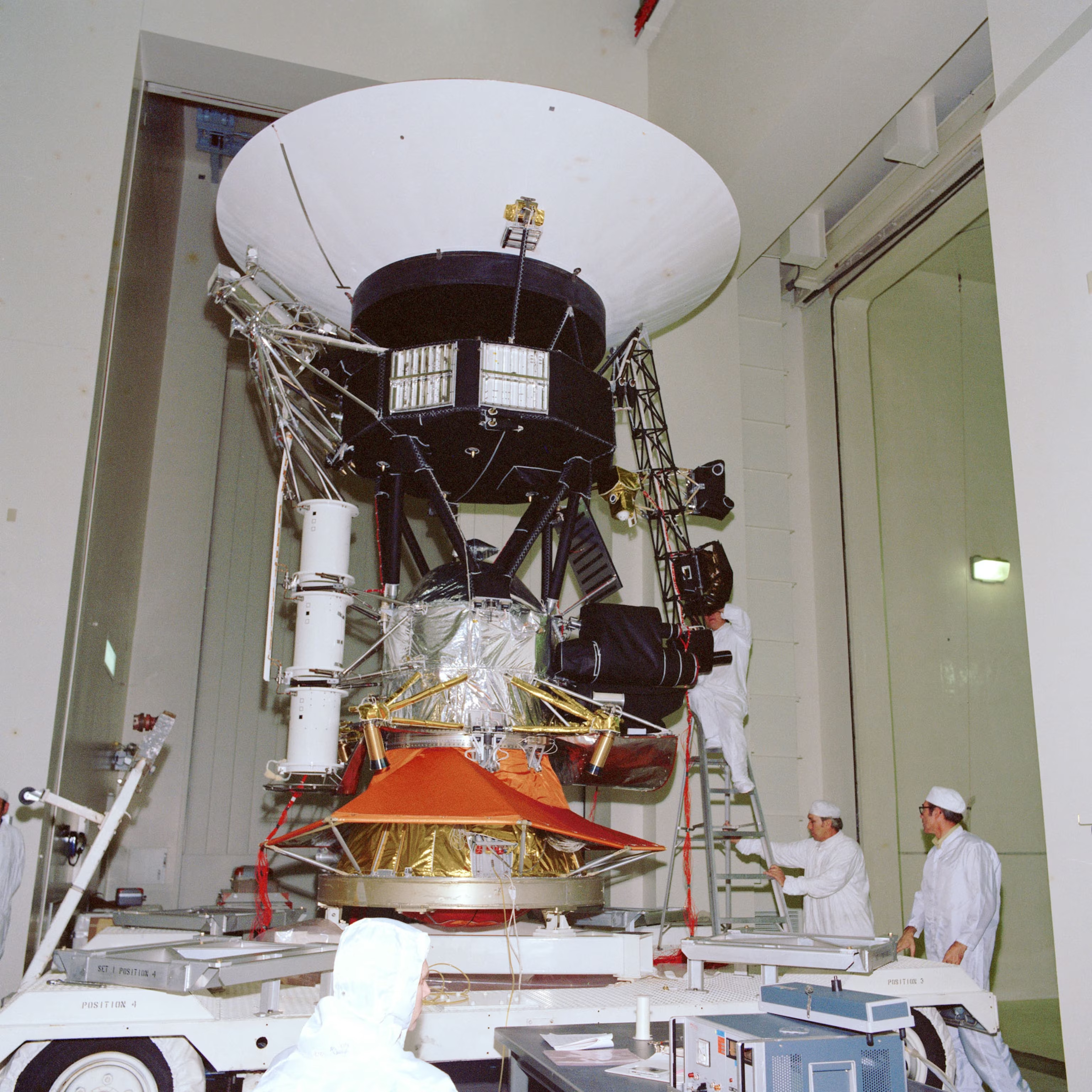 A Voyager spacecraft undergoing testing in a clean room at JPL in November 1976.