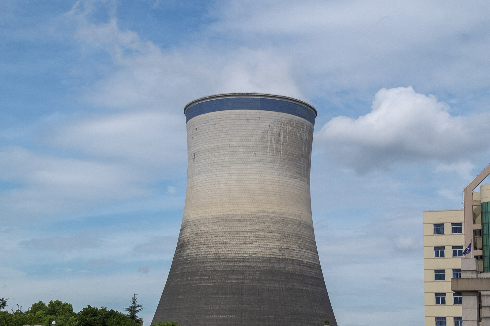 Steam rises from a large power-plant cooling tower.