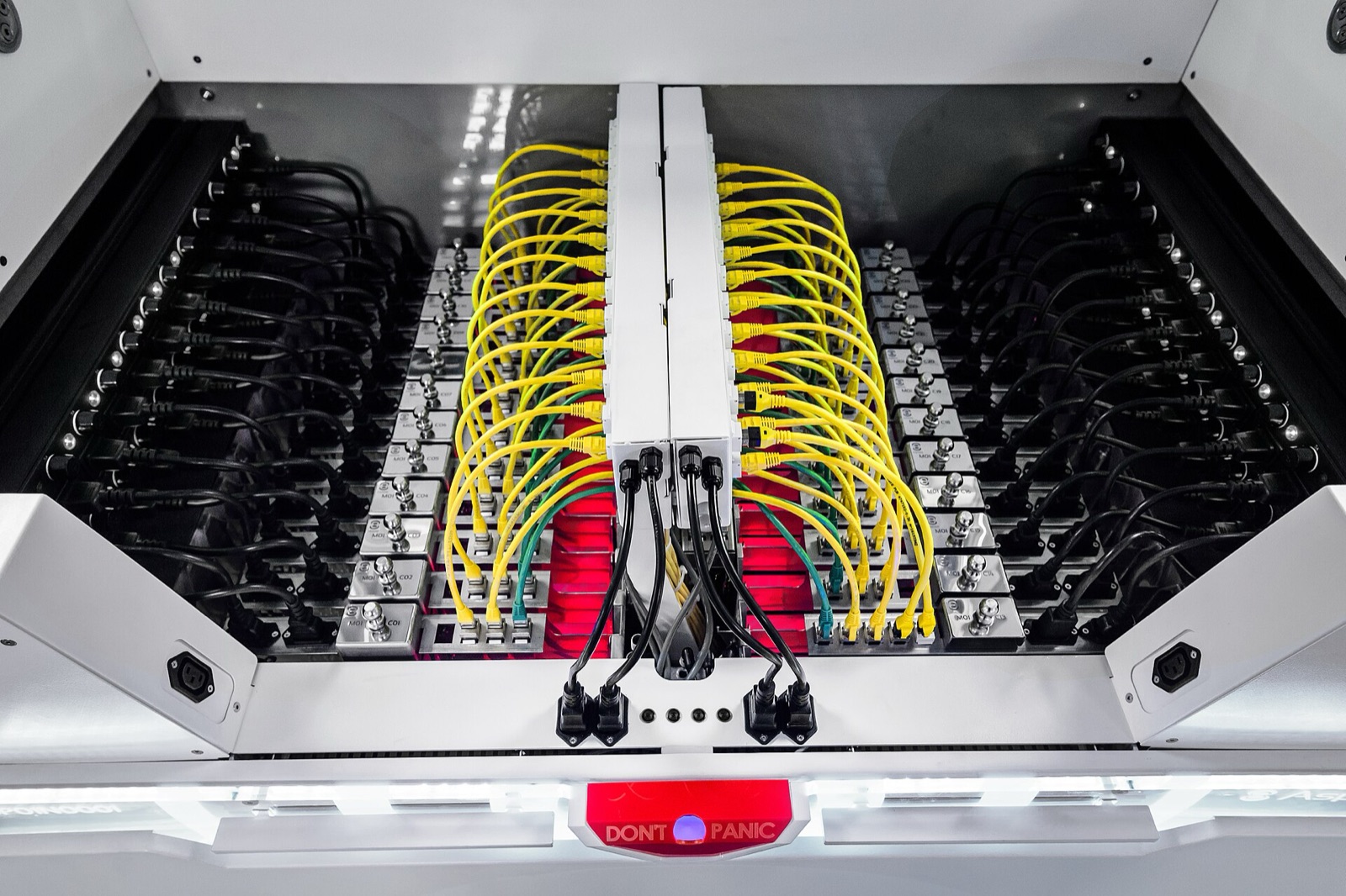 Looking down into an open immersion cooling tank, servers submerged in dielectric fluid with yellow network cables