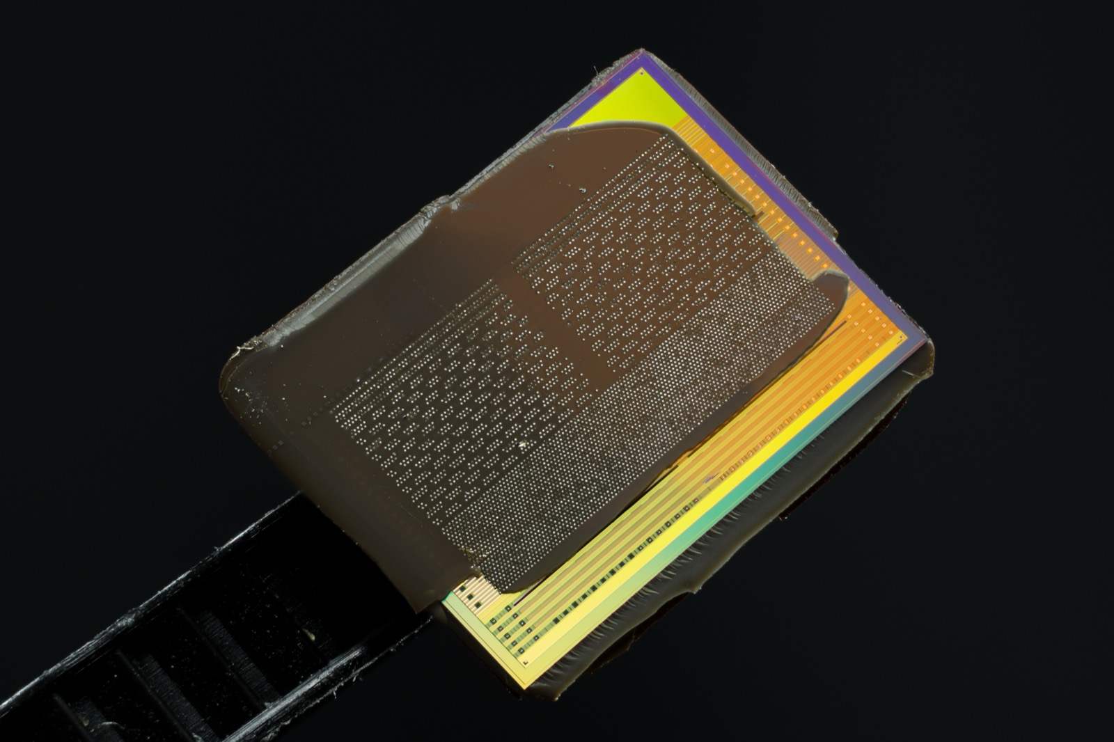A close-up of an HBM DRAM die, decapped from an AMD graphics package. Each of these wafer-thin layers must test as perfect before being stacked.