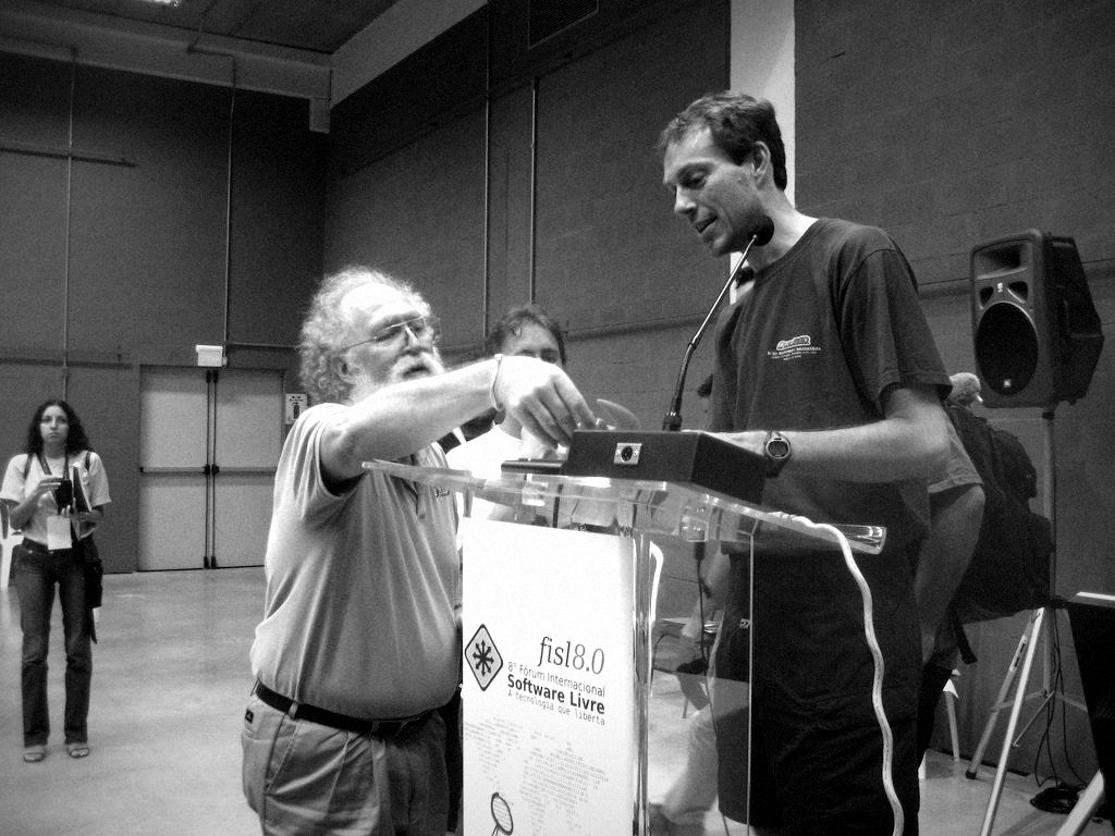 Jon "maddog" Hall hands Theo de Raadt a pair of devil horns, FISL 2007