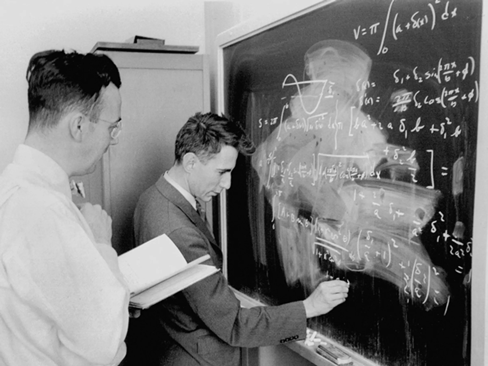 Claude Shannon at a chalkboard with a colleague at Bell Labs, working through equations